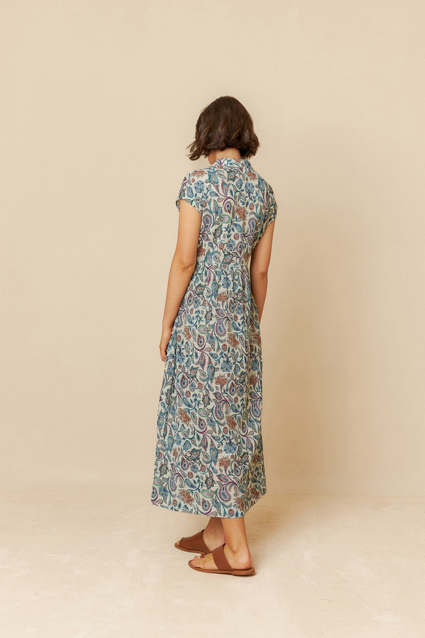 Woman wearing a floral dress against a beige background